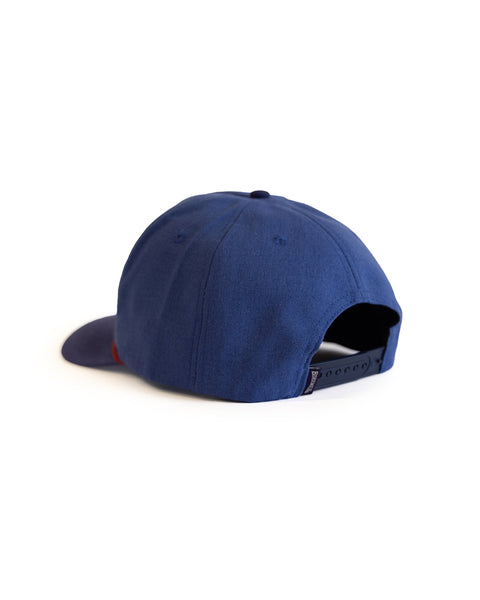 Back of blue hat with a dark navy rim with text on a white background