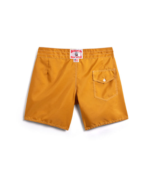 The 310 Boardshorts - Gold are mustard yellow Birdwell board shorts with a back pocket featuring a flap and button, plus a white label with red text on the waistband.